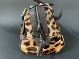 brown and black purse with leopard print on it on a table