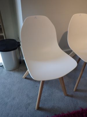 deux chaises blanches placées l'une à côté de l'autre dans une pièce