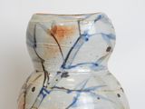 a white vase with blue and brown designs on it