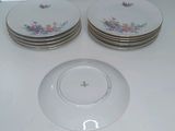 four plates with flowers on them sitting on a table