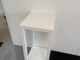 a small white table with a black mat on the floor