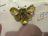 une petite broche en forme de papillon jaune posée sur une assiette blanche
