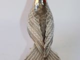 an image of a silver bird sitting on top of a white table