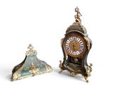 two clocks sitting next to each other on a white surface
