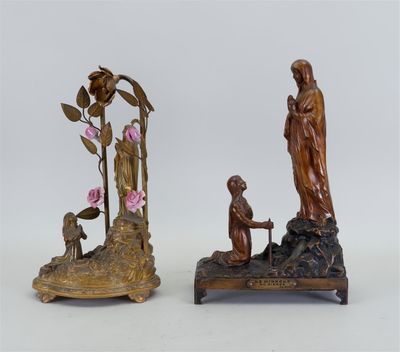 deux figurines en bronze représentant une femme et un homme avec des fleurs