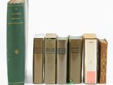 plusieurs livres sont alignés sur une surface blanche