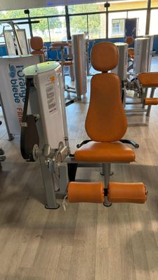 an orange chair in the middle of a gym room