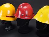 three yellow and red hard hats sitting on top of each other