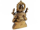 brass statue of a person sitting on a rock with his hands in the air