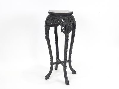 une table noire avec un plateau en marbre posée sur une surface blanche