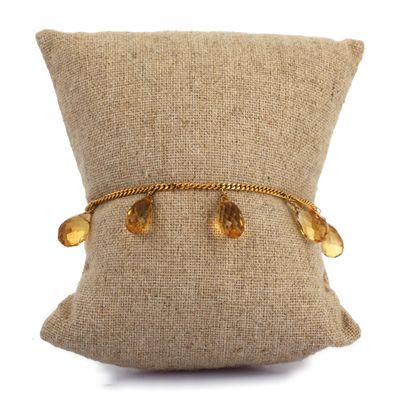 un gros plan sur un oreiller sur lequel repose un bracelet en or