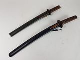 deux sabres de samouraï posés sur une surface blanche, avec un manche noir