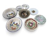many different types of plates and bowls on the table