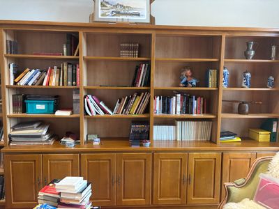 a book shelf with many books on it in a living room