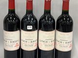 three bottles of red wine are lined up on a white surface