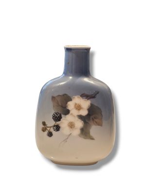 a blue vase with white flowers on it on a white background
