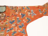 an orange and blue embroidered jacket with a dragon on it