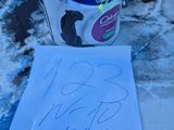 un pot de peinture posé par terre à côté d'une feuille de papier