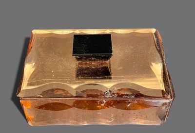 a glass box with a black lid sitting on a table