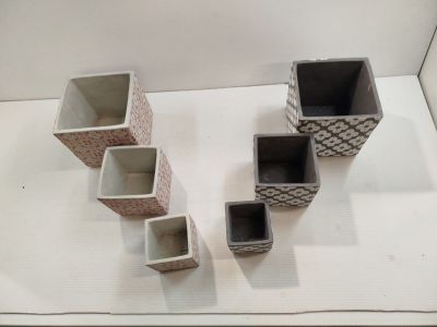 quatre types de vases différents posés sur une surface blanche