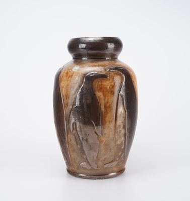 a brown vase with a black lid sitting on a white surface