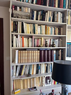 une lampe posée sur une table devant une bibliothèque