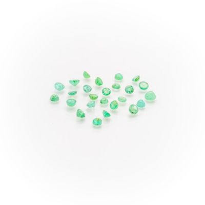 a group of green tourmaline gems on a white surface