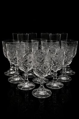 six wine glasses are lined up in a row on a black surface