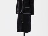 une image d'un manteau noir sur un support de mannequin
