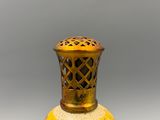 a yellow vase sitting on a table with a gray background