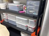 a black shelf with plastic containers on top of it