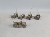 several toy army vehicles are lined up in a row on a white surface