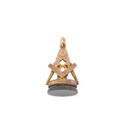 un gros plan d'un pendentif en or orné d'un symbole maçonnique