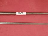 two old swords are on a red surface with a tag