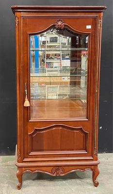 une vitrine ancienne en bois avec une porte vitrée