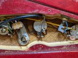 a red car door with a bunch of electrical wires in it