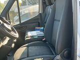 une camionnette blanche avec des sièges noirs et un ordinateur portable sur le siège passager