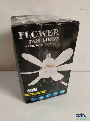 une boîte contenant un ventilateur de plafond blanc posée sur une table
