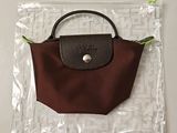 un sac à main marron et noir dans un sac transparent