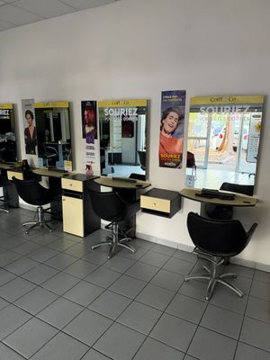de nombreux fauteuils dans le salon, où les clients attendent de se faire couper les cheveux