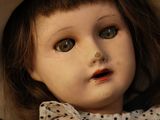 a close up of a doll with a hat on