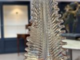une figurine en verre représentant une feuille, posée sur une table