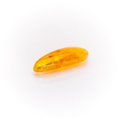a yellow oval shaped stone on a white surface