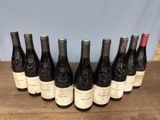six bottles of wine are lined up on a wooden table