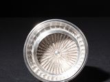 a close up of a silver plate on a black surface