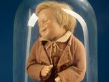 a small doll in a glass jar on a table