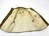 an old jacket with writing on it sitting on top of a white surface