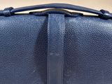 a close up of a blue leather bag with a metal clasp