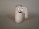 a white vase that has a handle on it