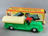 un petit camion vert avec un homme à l'arrière